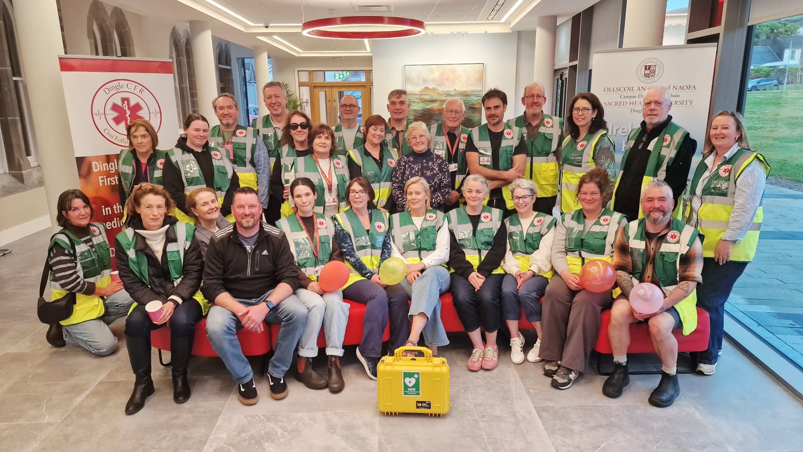 The Dingle Heart Safe volunteer team in high-visibility vests, gathered around an AED